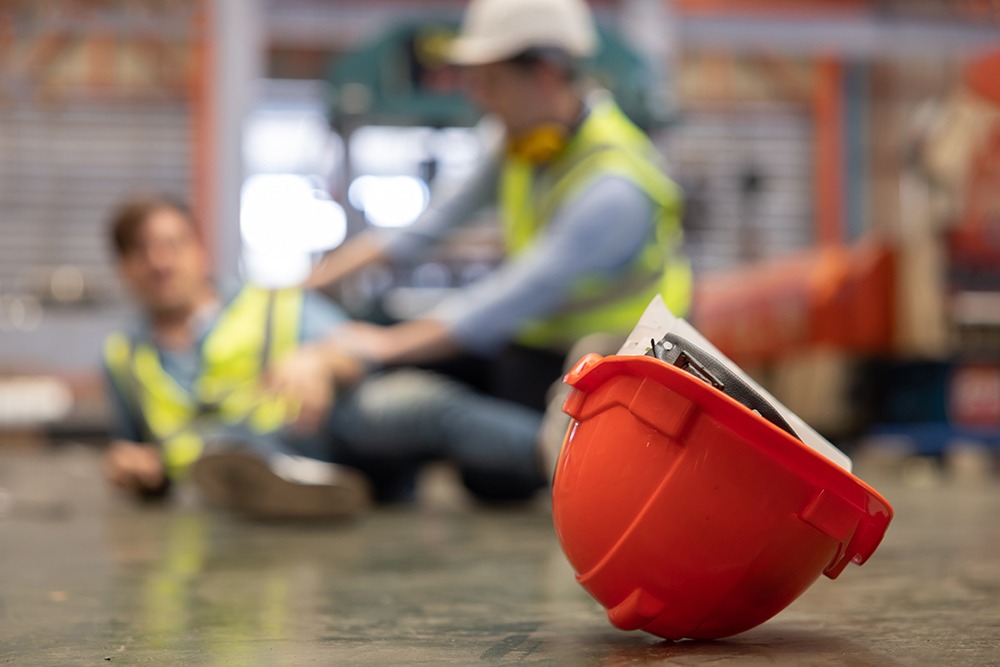 Workplace injury lawyer in Naples, FL assisting construction worker injured on job site with legal advice and medical care.