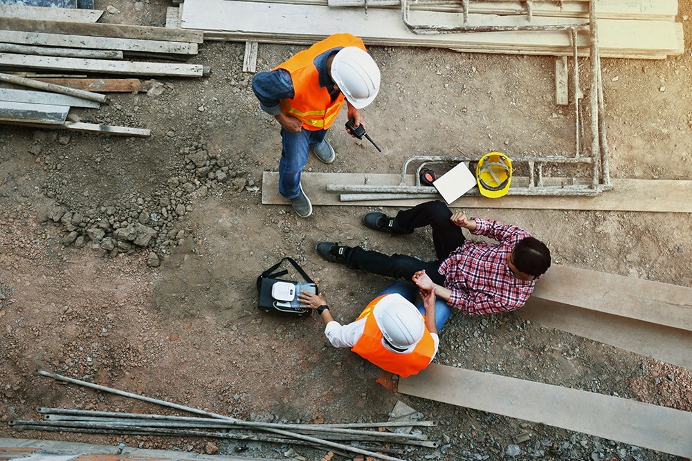 Construction accident injury victim receiving medical attention for serious injuries caused by equipment failure