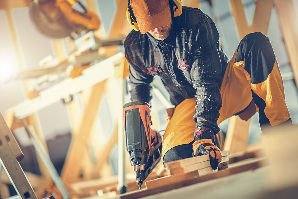 Florida construction workers on a job site wearing safety gear, representing common workplace injury risks such as hearing loss, respiratory illness, falls, and heavy equipment accidents.